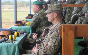 Představitelé cvičících armád a hosté sledují dynamickou ukázku bojové činnosti